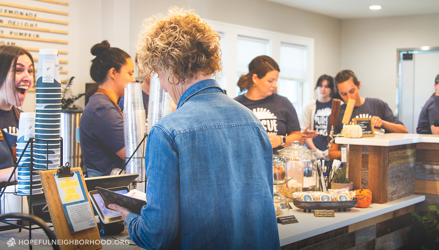 Woman making a purchase at the counter of a coffee shop