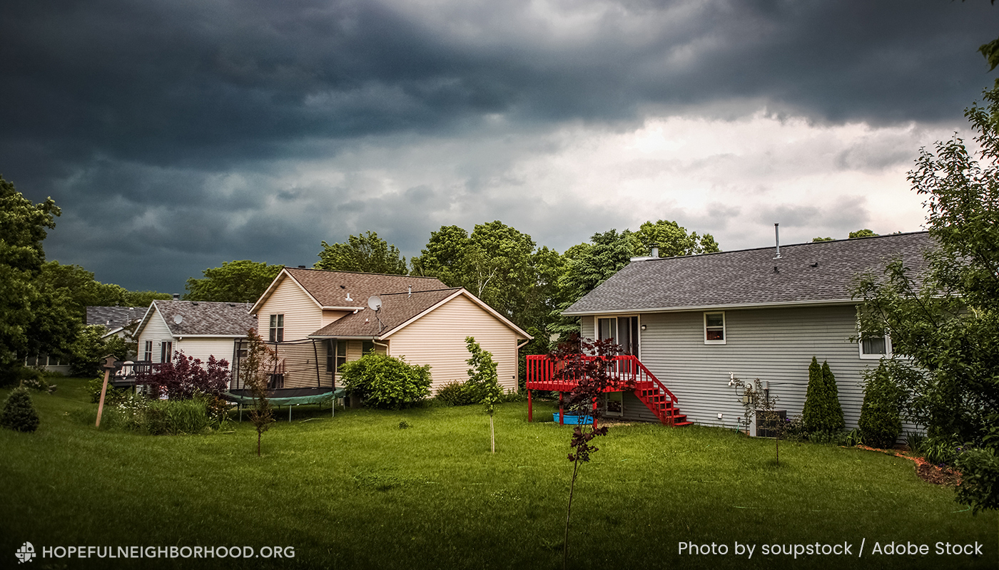 Photo of a suburban neighborhood with a storm overhead.