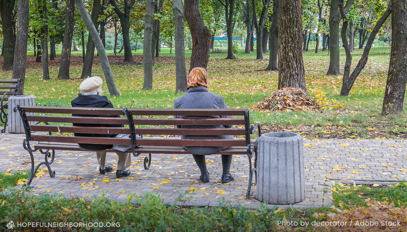 Grieving neighbors sitting on a bench together.
