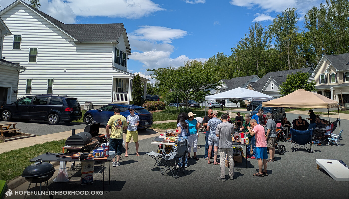 Photo of a block party in the middle of the street in a middle class neighborhood.