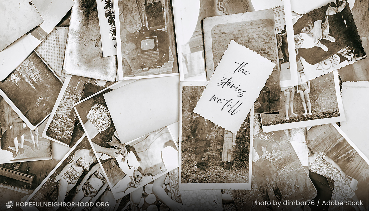 2026-blog_hnp-storieswetell1 Stacks of black and white family photos scattered on a table, the back of one showing the text, "The Stories We Tell".